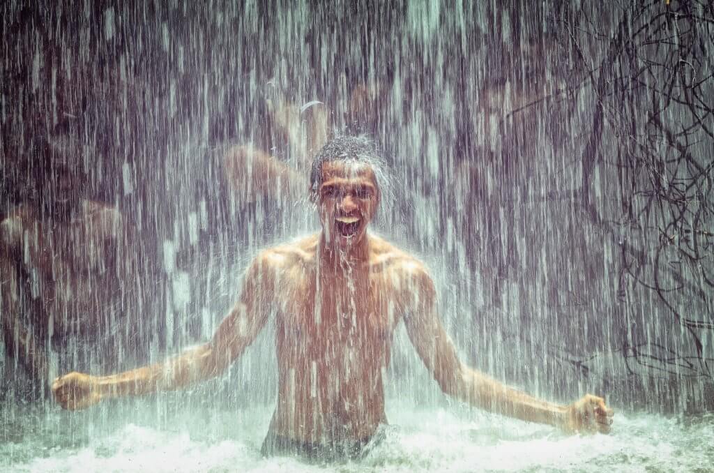 Exhilarated man in waterfall